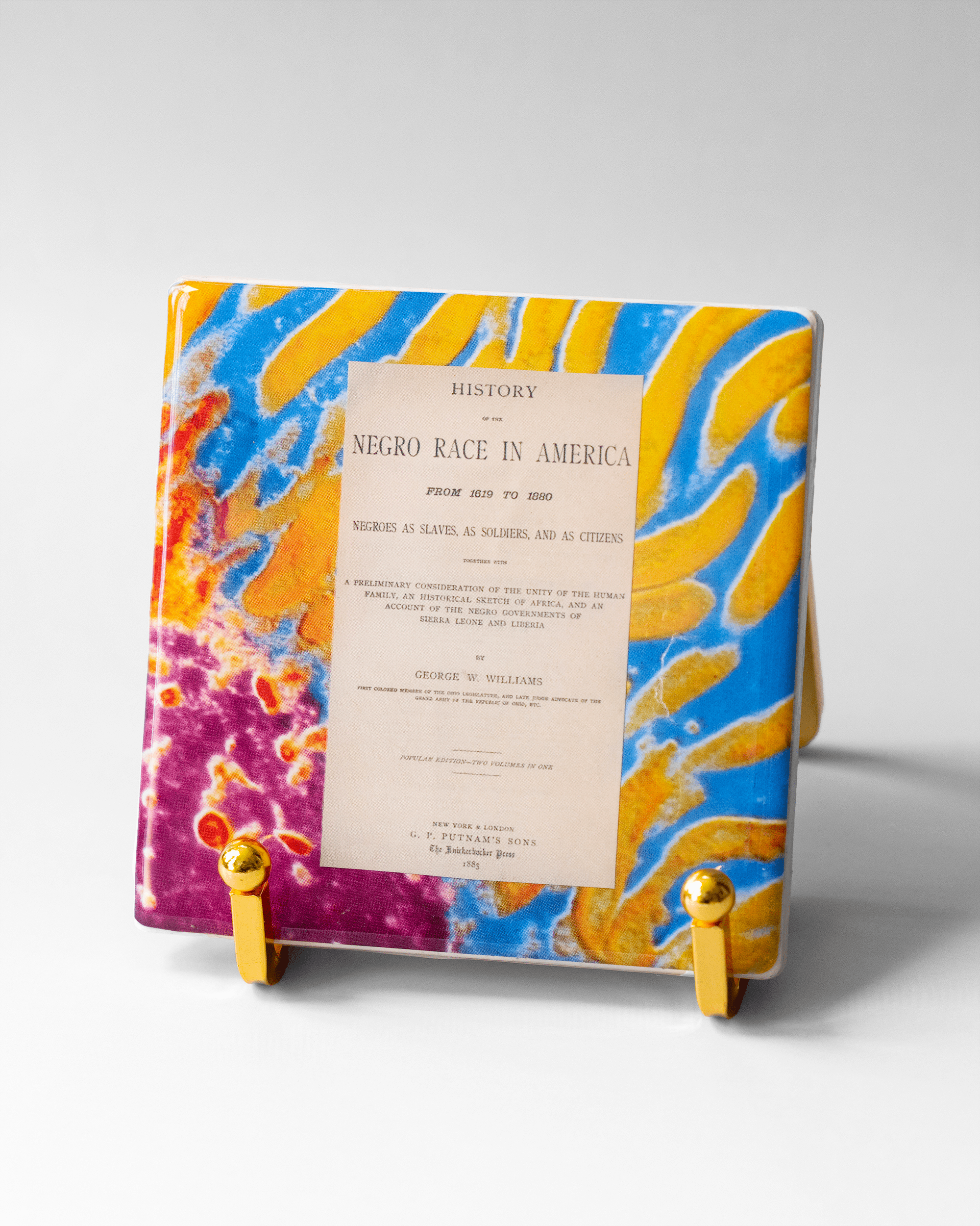 Histories Within x Microscopy | Display Coaster - Quantum Sunshine. Handmade art tile featuring vivid microscopy sealed in resin. Science-inspired wearable art and meaningful science gift for doctors and STEM professionals. History and resistance home decor. On stand.