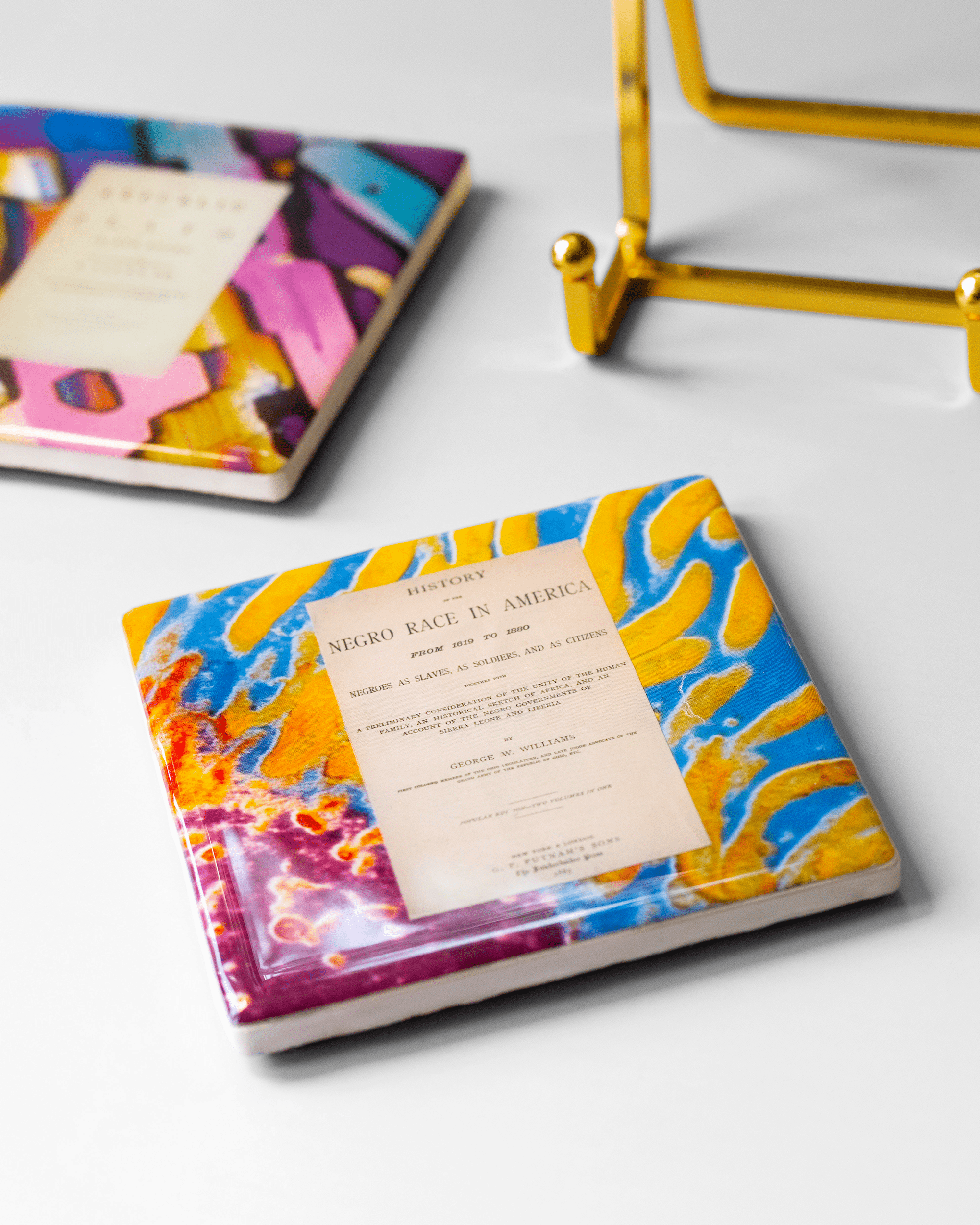 Histories Within x Microscopy | Display Coaster - Quantum Sunshine. Handmade art tile featuring vivid microscopy sealed in resin. Science-inspired wearable art and meaningful science gift for doctors and STEM professionals. History and resistance home decor. Flat lay.