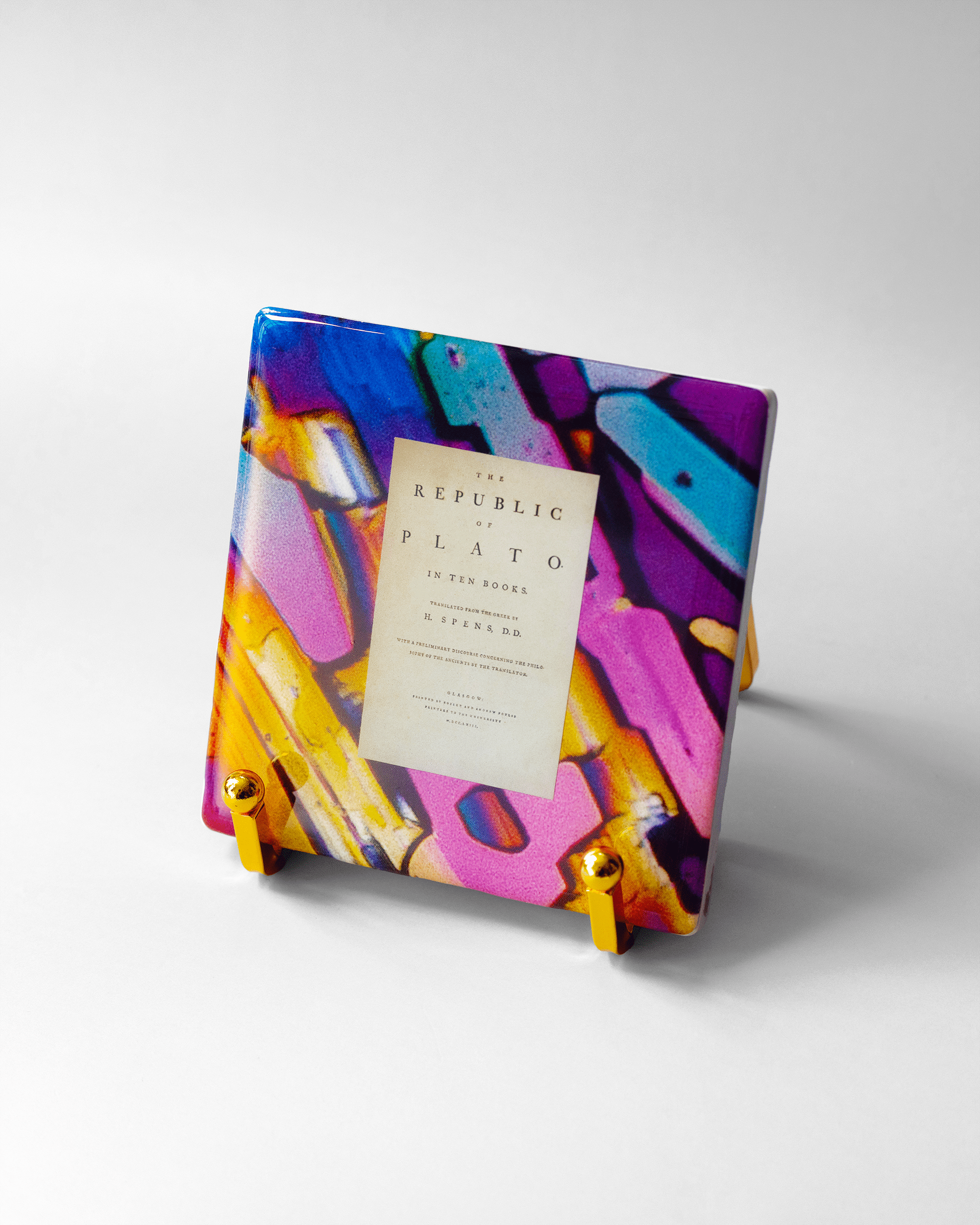 Plato’s Republic x Microscopy | Display Coaster - Quantum Sunshine. Handmade art tile featuring vivid microscopy sealed in resin. Science-inspired wearable art and meaningful science gift for doctors and STEM professionals. History and resistance home decor. On stand.