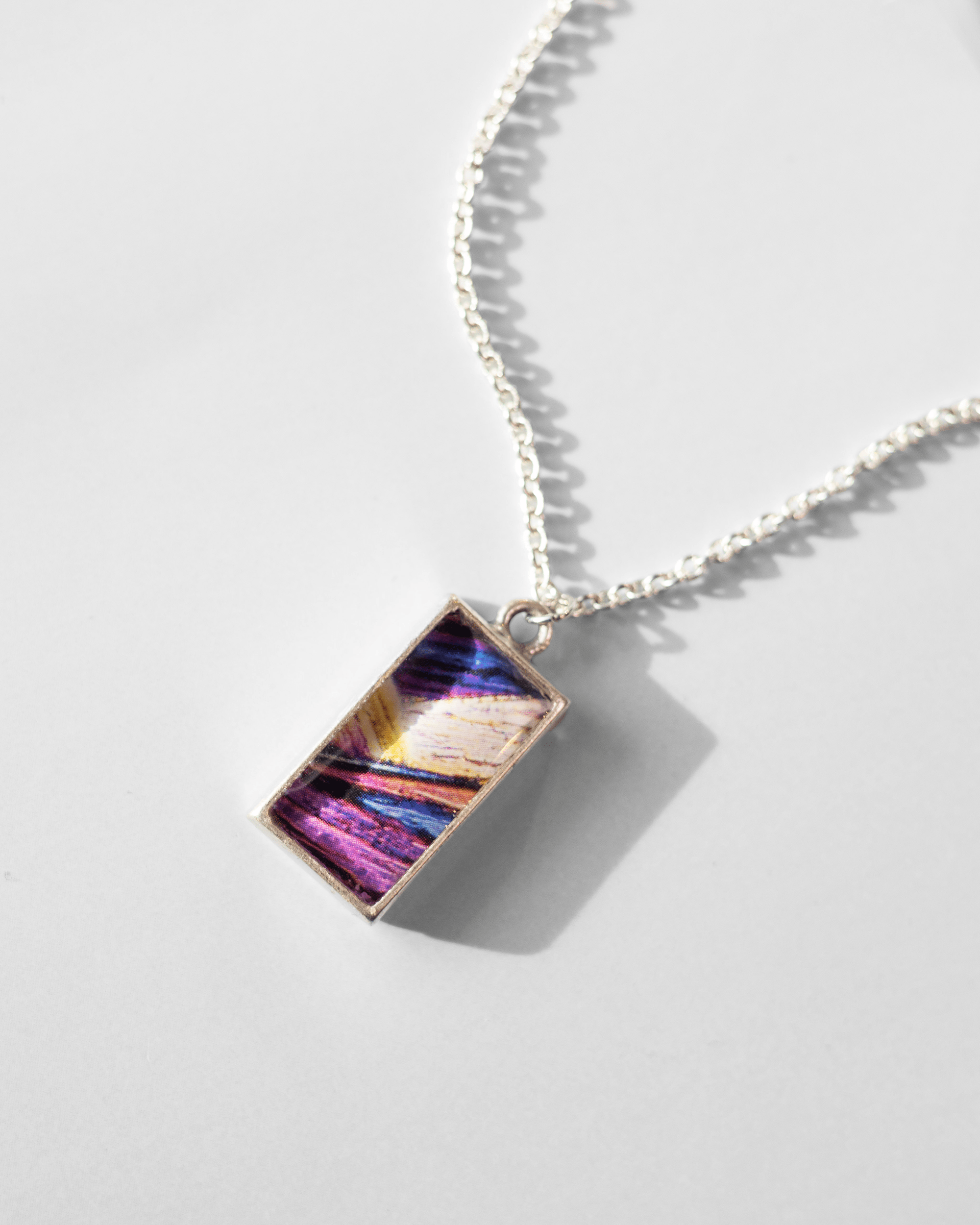 Arresting Necklace - Quantum Sunshine. Handmade jewelry featuring vivid microscopy sealed in resin. Science-inspired wearable art and meaningful science gift for doctors and STEM professionals. Up close.