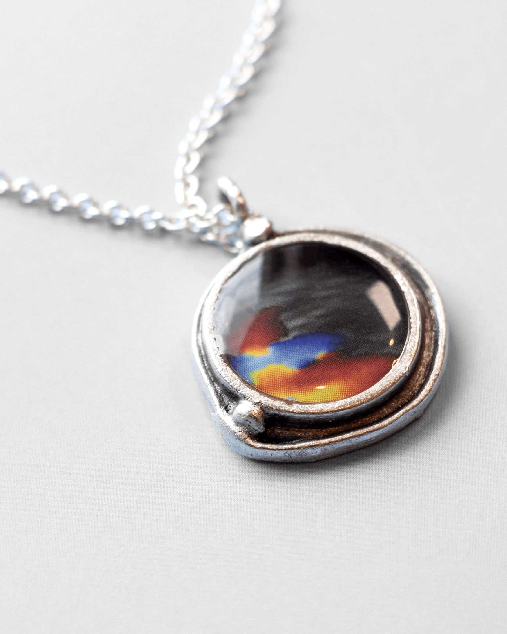 Handmade ultrasound heartbeat necklace in resin. Colorful, wearable science art pendant honoring rhythm, emotion, and vitality. Macro.