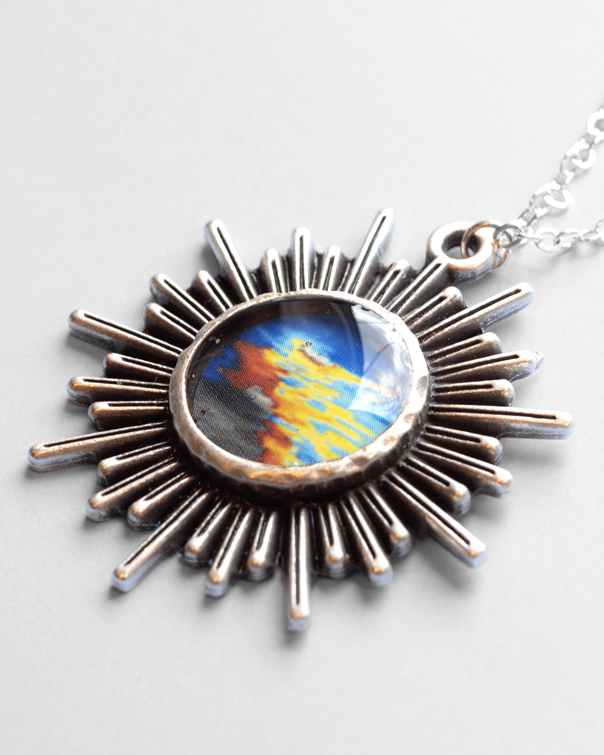 Handmade ultrasound heart necklace featuring real heart imagery. Vibrant sun shaped anatomical science jewelry gift for women in STEM and medicine. Macro shot.