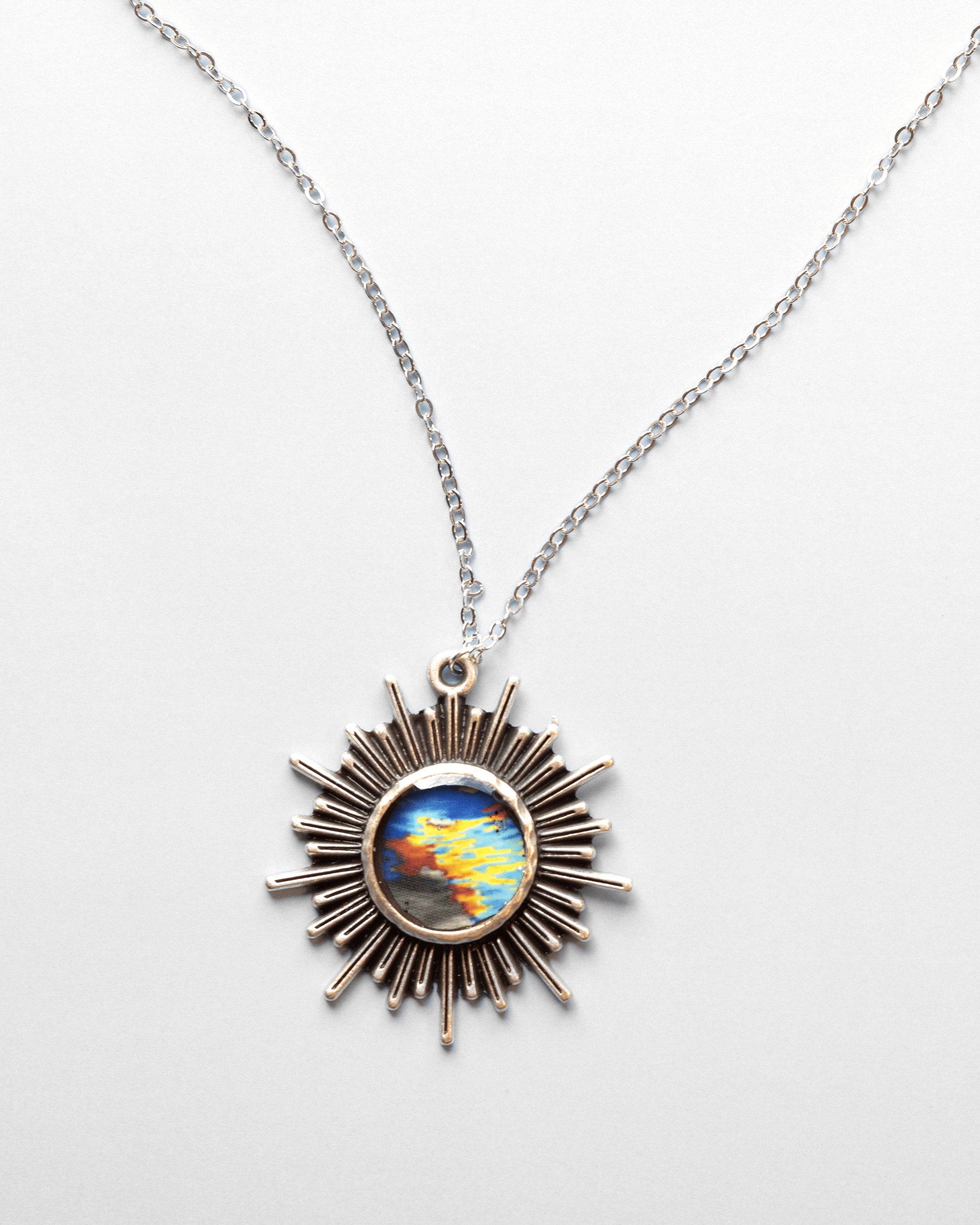 Handmade ultrasound heart necklace featuring real heart imagery. Vibrant sun shaped anatomical science jewelry gift for women in STEM and medicine. Front.