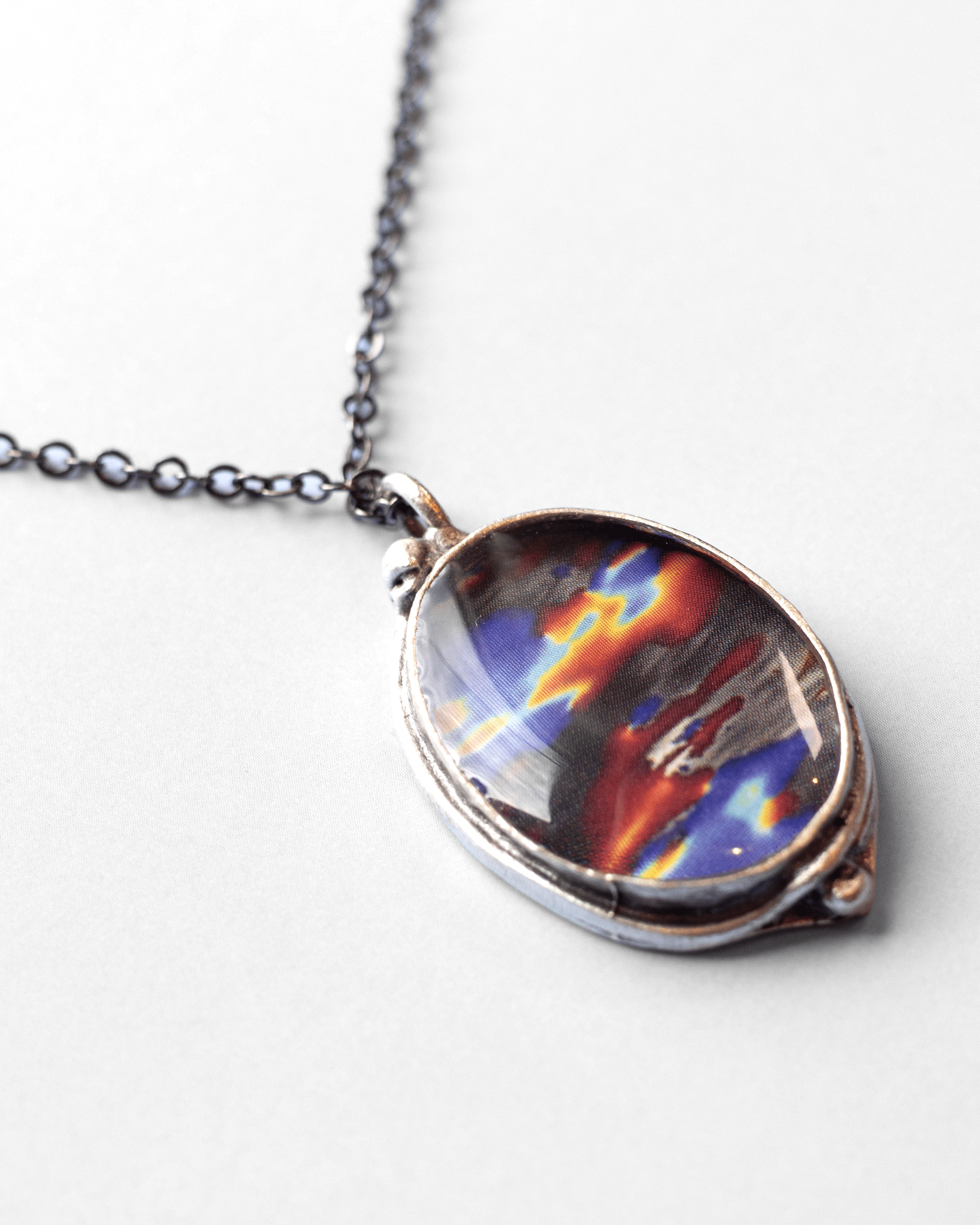 Ultrasound heart necklace handmade in resin and gold-tone finish. Colorful and elegant science jewelry celebrating love, anatomy, and art. Macro.