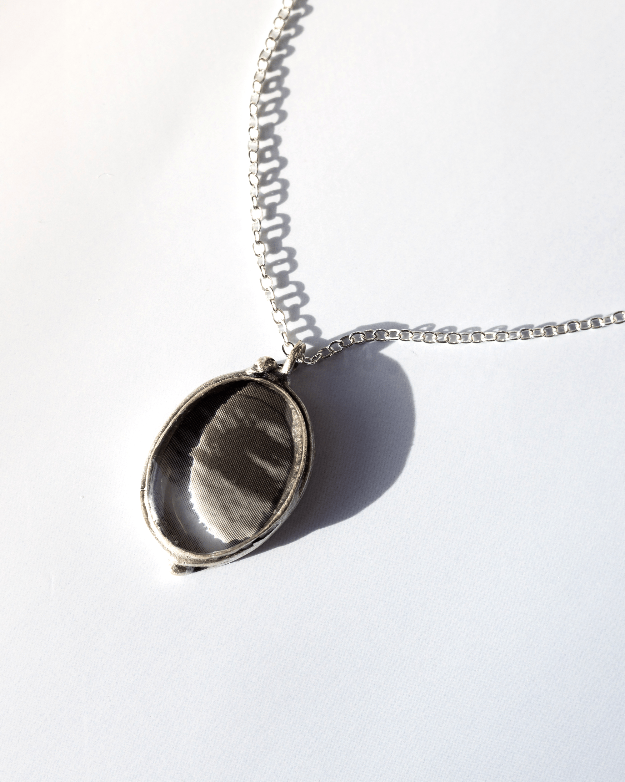 Handmade ultrasound heart necklace in resin and silver-plated brass. Anatomical science jewelry gift inspired by motion and vitality. Up close.