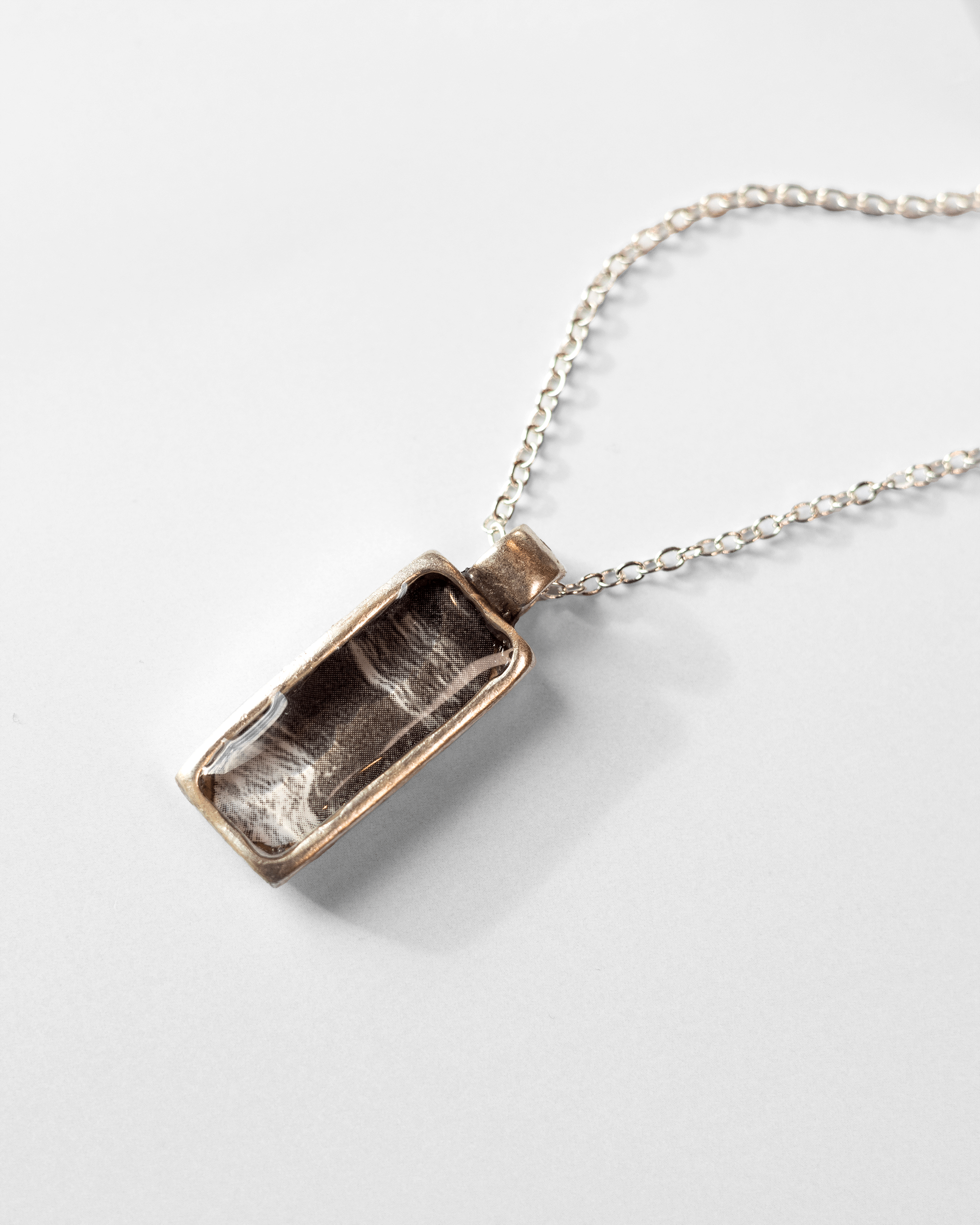 Ultrasound heartbeat necklace handmade in resin. Science jewelry art pendant symbolizing rhythm, sound, and human connection. Up close.